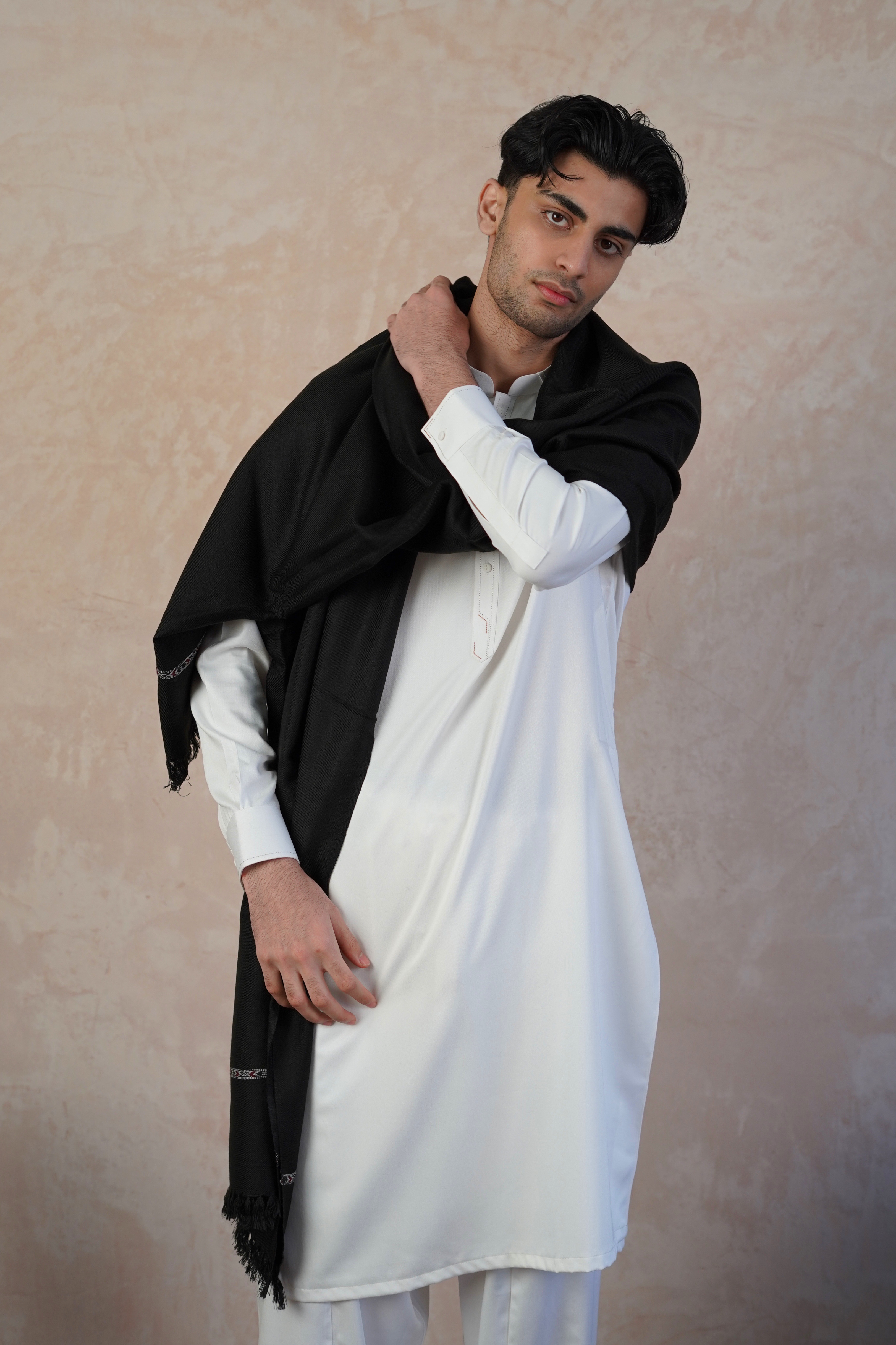 Pakistani male model wearing UD Fabrics white shalwar kameez and Black shawl