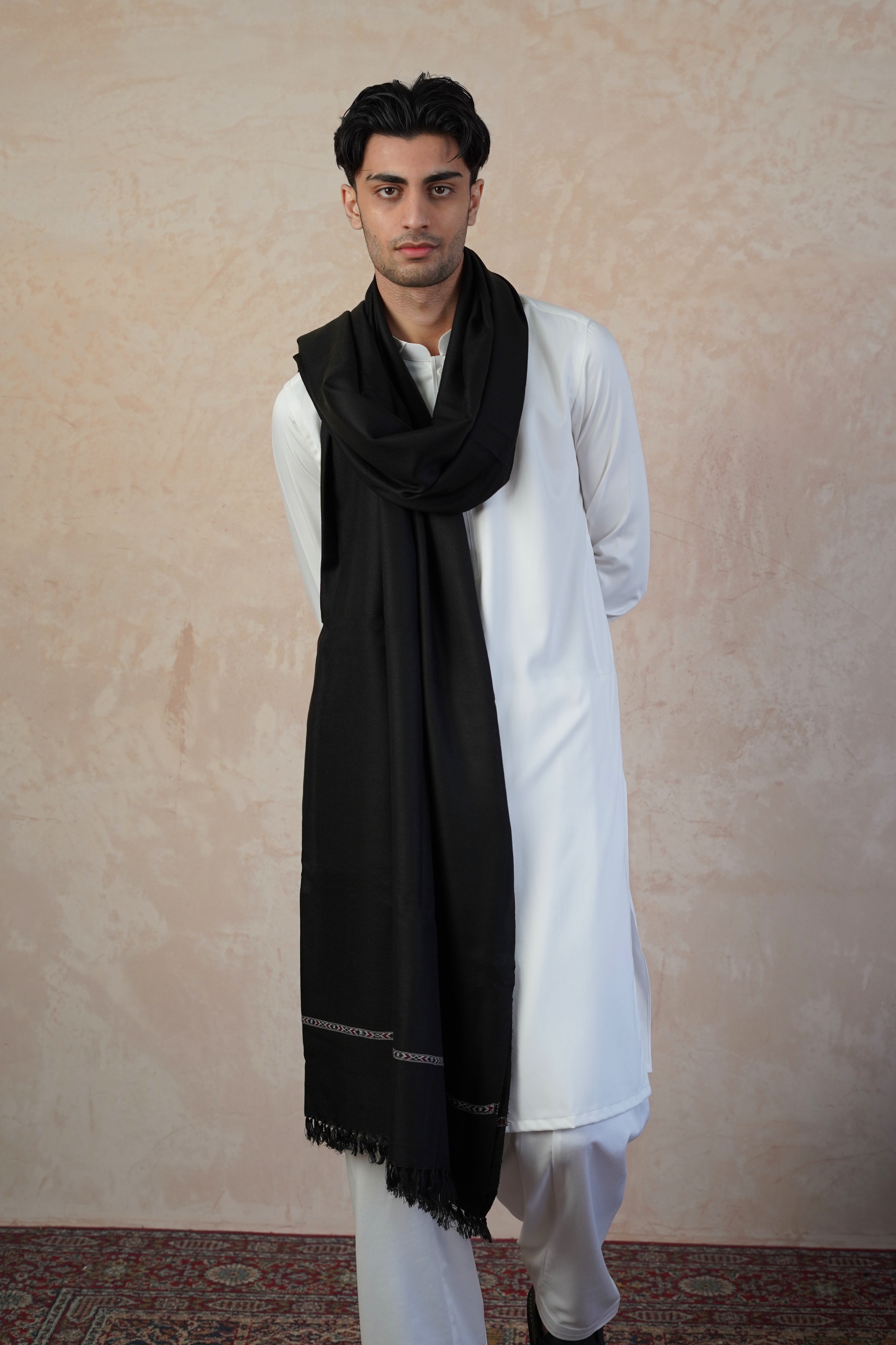 Pakistani male model wearing UD Fabrics white shalwar kameez and Black shawl