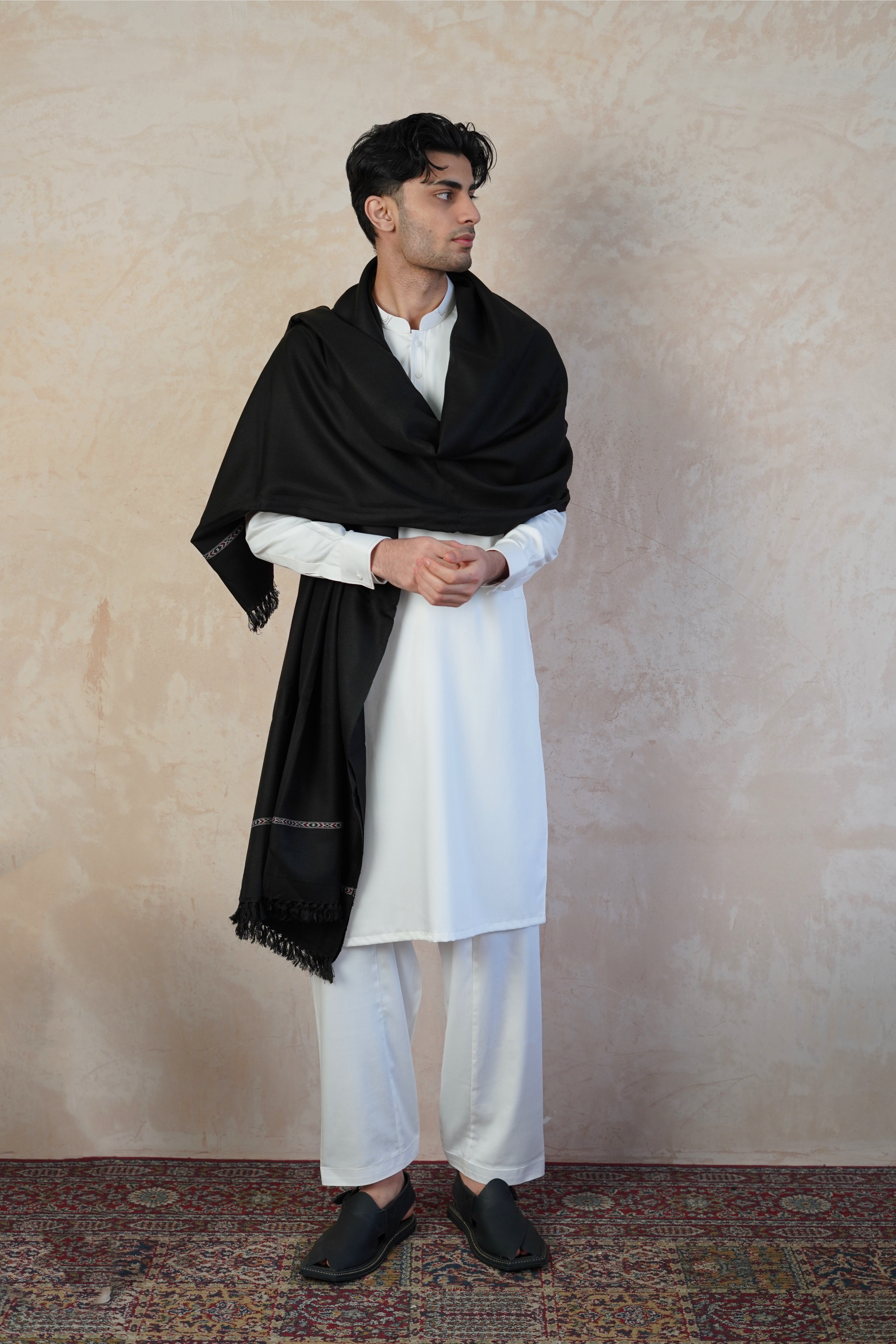 Pakistani male model wearing UD Fabrics white shalwar kameez and Black shawl