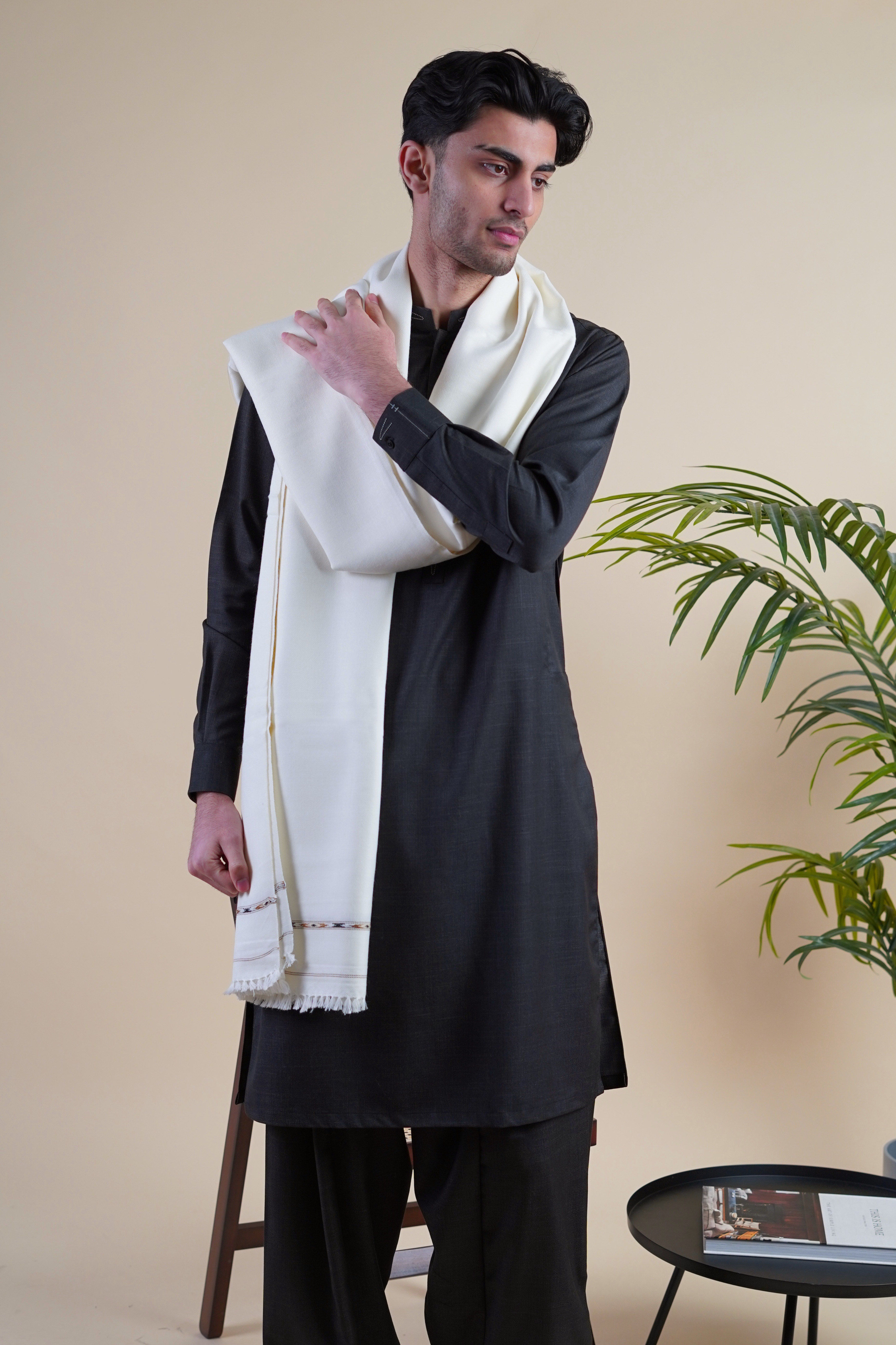 Pakistani male model wearing UD Fabrics black shalwar kameez and off white shawl 